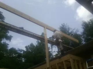 Carpenter setting a ridge beam over a new addition frame — Ice Dam Removal by Roofing Brothers in Bucyrus