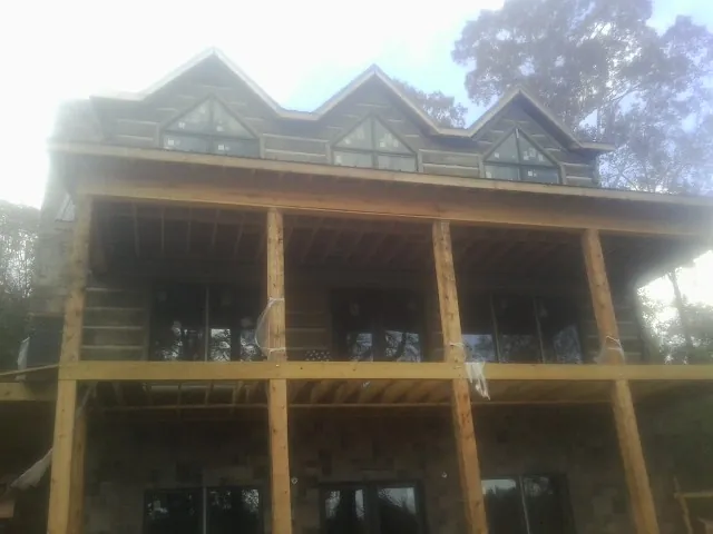 Dormers and porch framing on a large log home under construction — Roof Coating work by our crew in Bucyrus