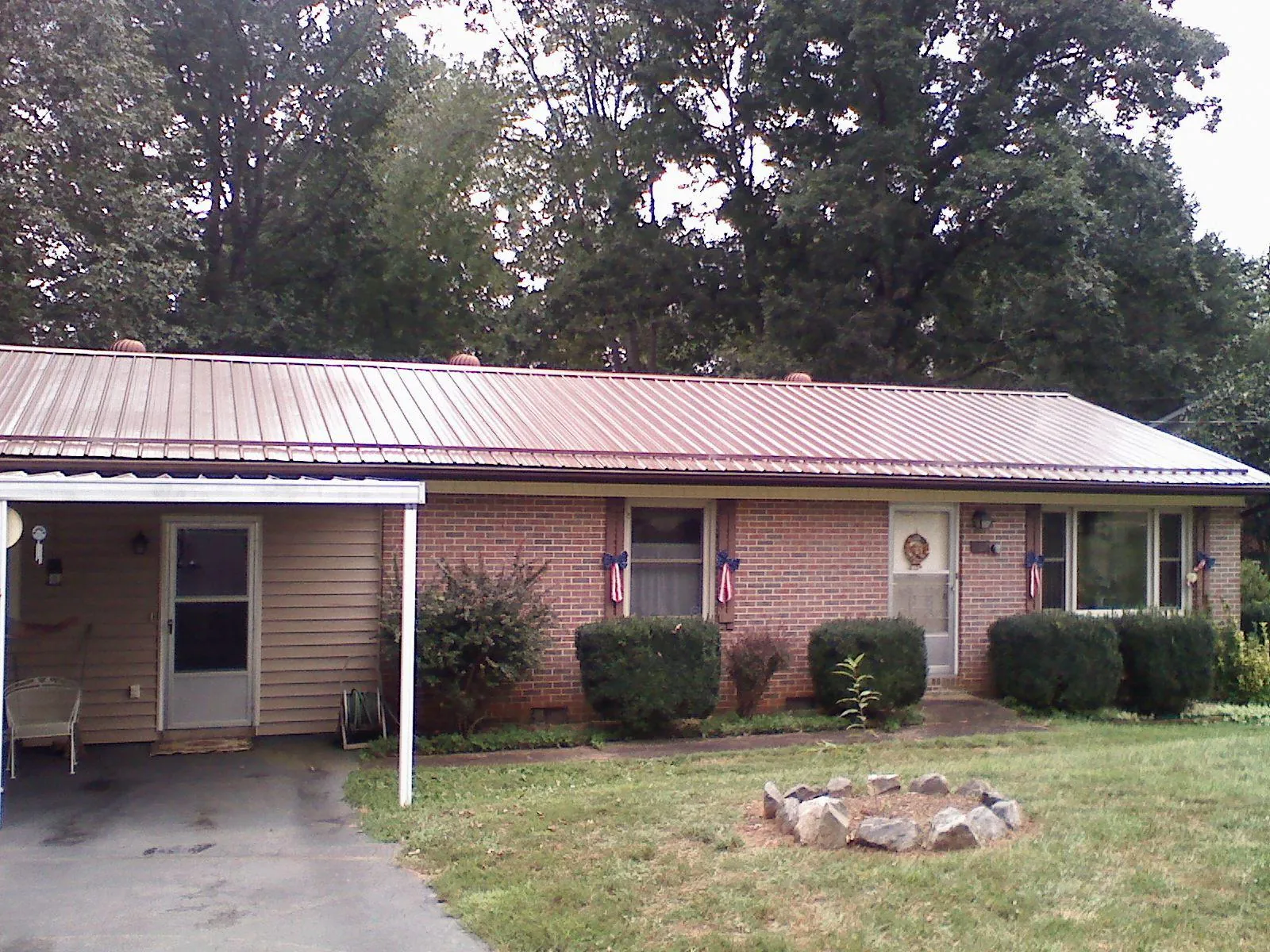 Bronze metal roof and carport on a brick ranch home — Roof Repair work by our crew in Bucyrus